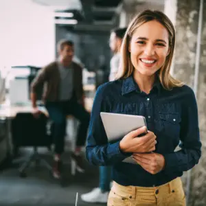 Une collaboratrice souriante dans un bureau, illustration du bien-être au travail