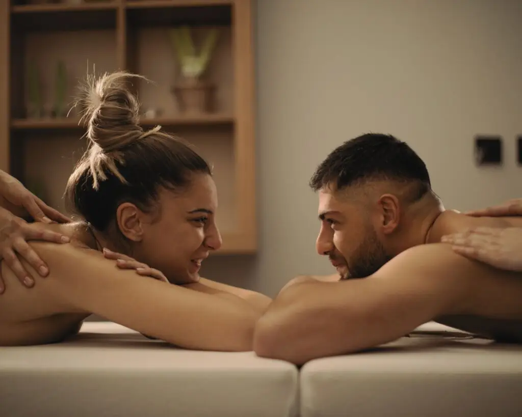 couple se regardant depuis leur table de massage lors d'un massage en duo chez ODAMAYA