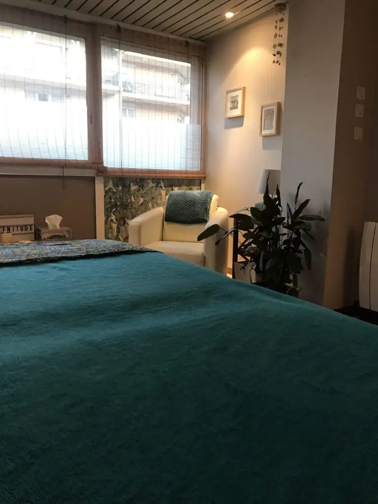 Table de massage et coin salon de la salle de soins Odamaya à Montrond-les-Bains