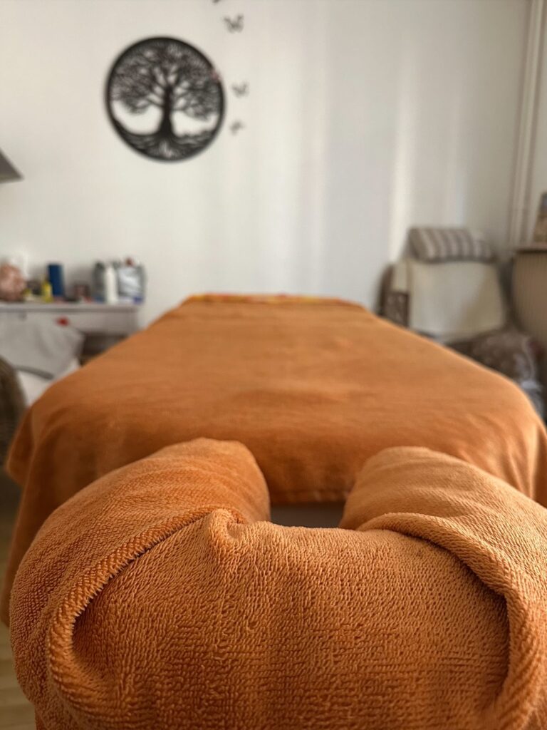 Table de massage préparée avec une serviette orange — salle l’Astrée, Montbrison