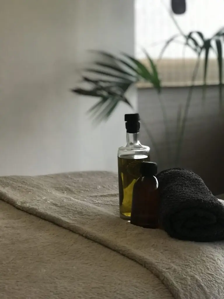 Huiles de massage et serviette roulée sur la table de soins — Bulle d’R, Montrond-les-Bains